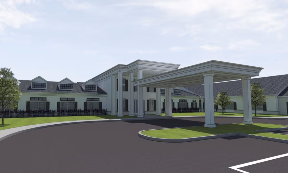 Modern senior living facility exterior with a grand entrance porte-cochere and circular driveway