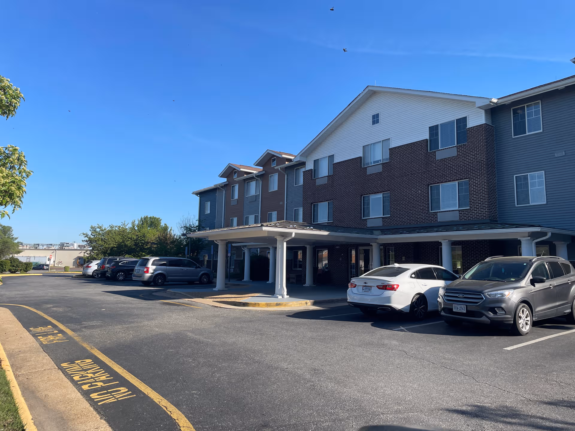 Paramount Senior Living at Fredericksburg exterior: brick building with a parking lot.