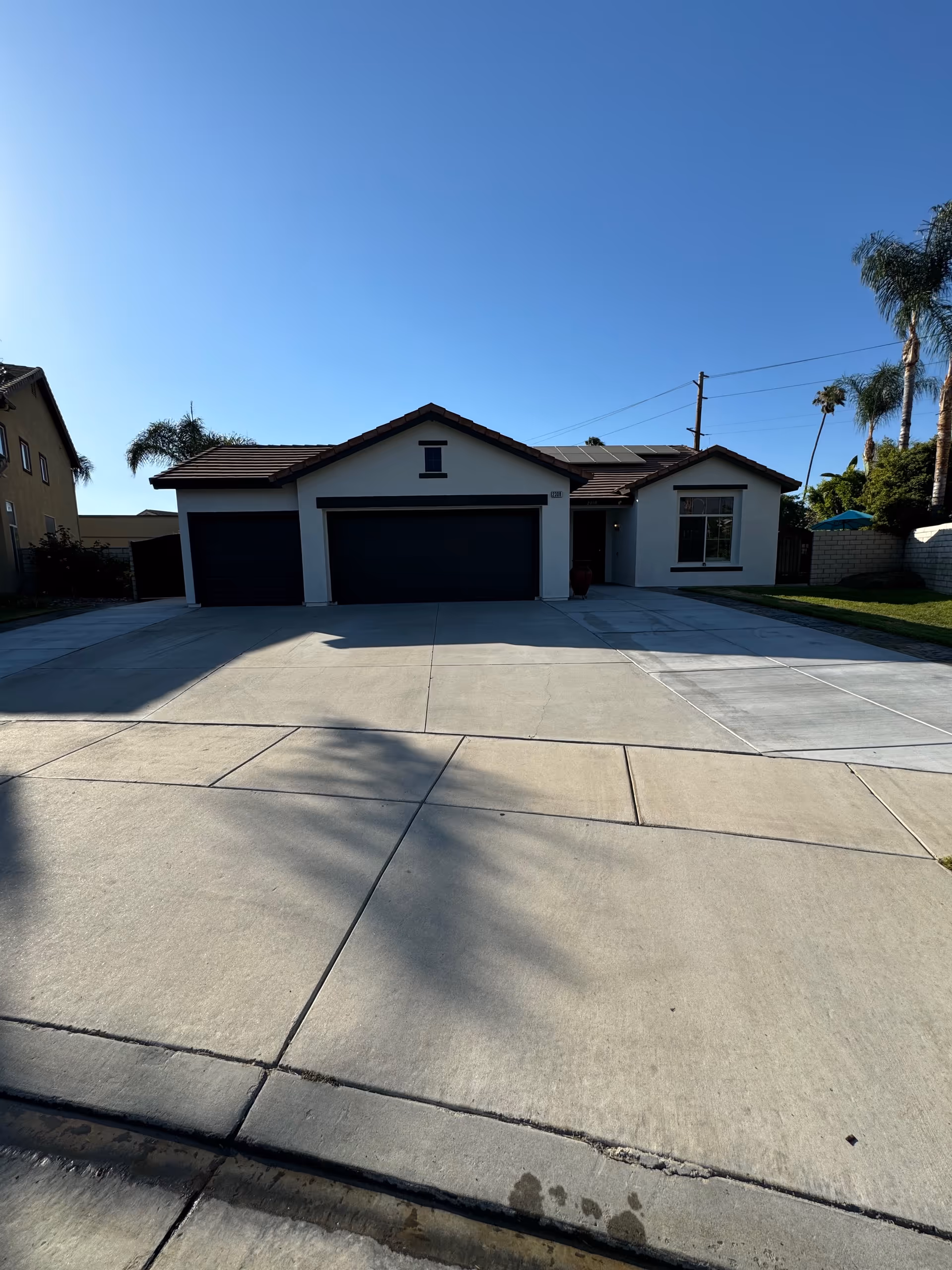 Exterior of a single-story house with three-car garage and wide driveway.