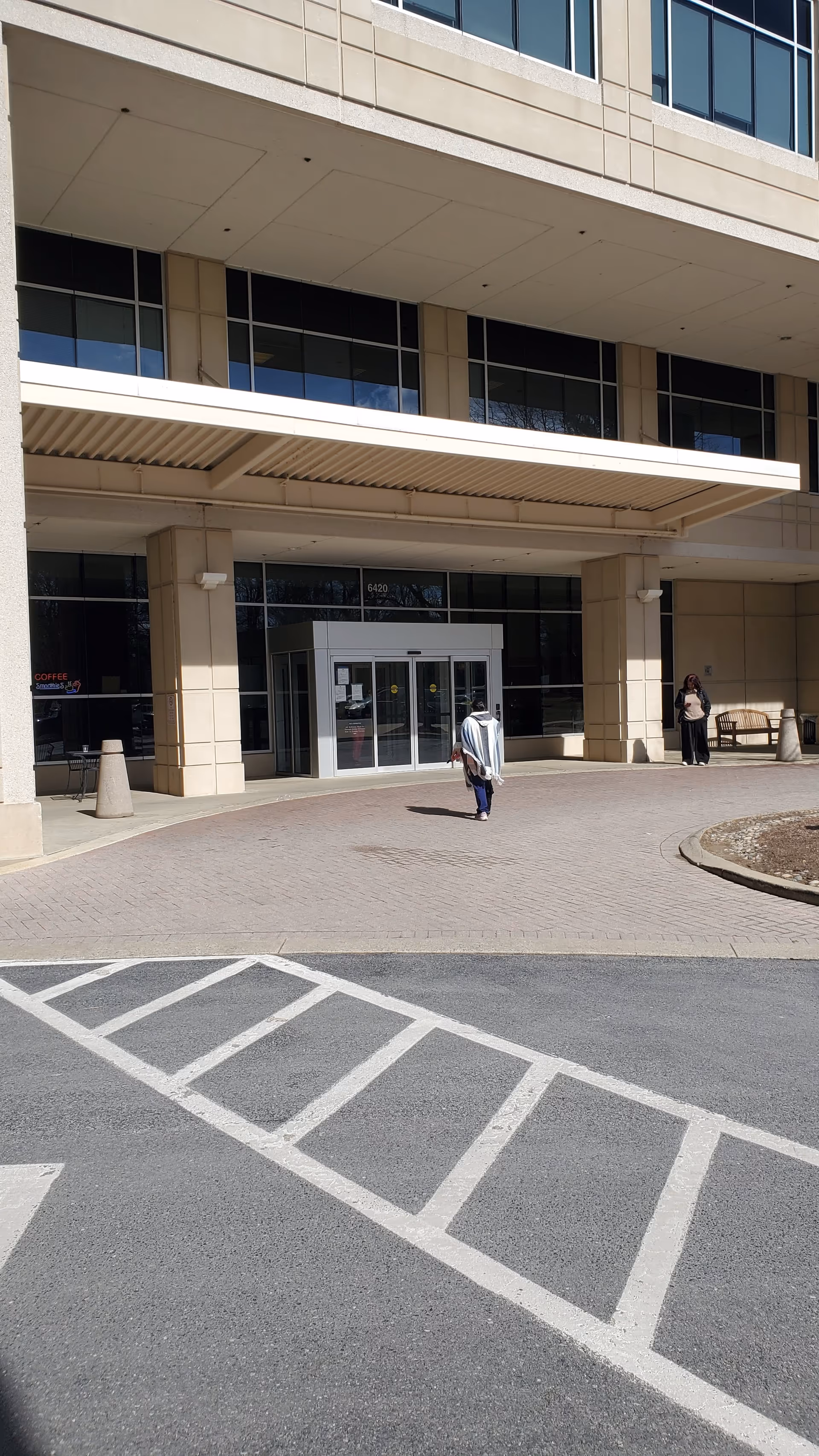 Exterior view of Johns Hopkins Health Care & Surgery Center entrance with pedestrians outside