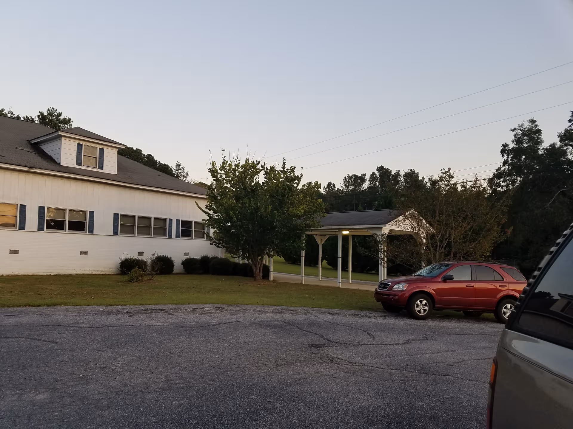 Exterior view of Nancy Hart Nursing Center with entrance canopy and a red SUV.