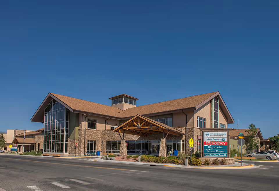 Modern senior living facility exterior with stone accents and a covered entrance.