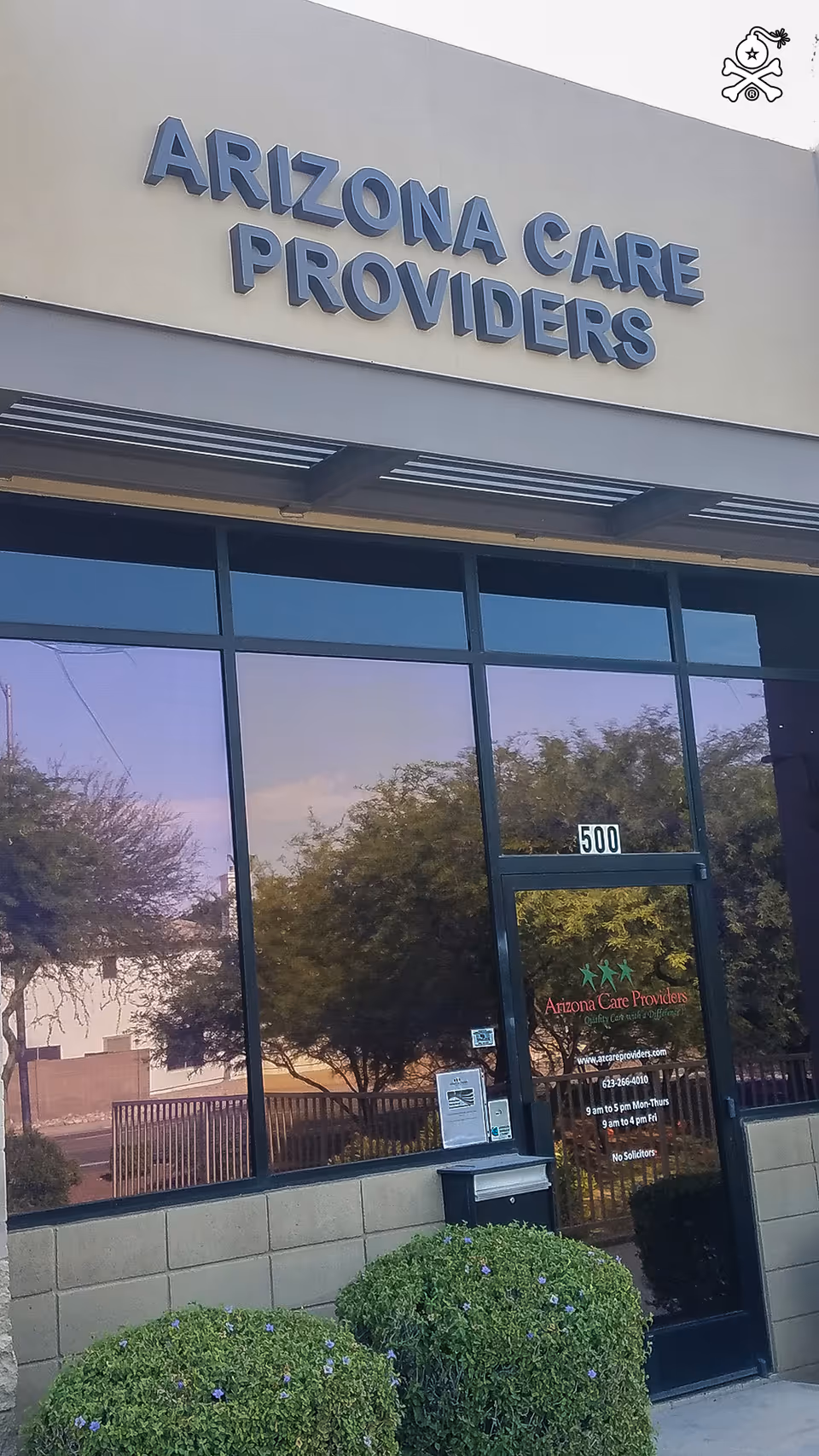 Front view of Arizona Care Providers facility showing the sign and glass entrance.