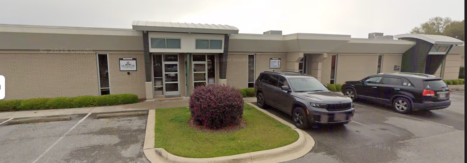 Front view of Always Best Care Senior Services facility with entrance, shrubs, and parked cars.