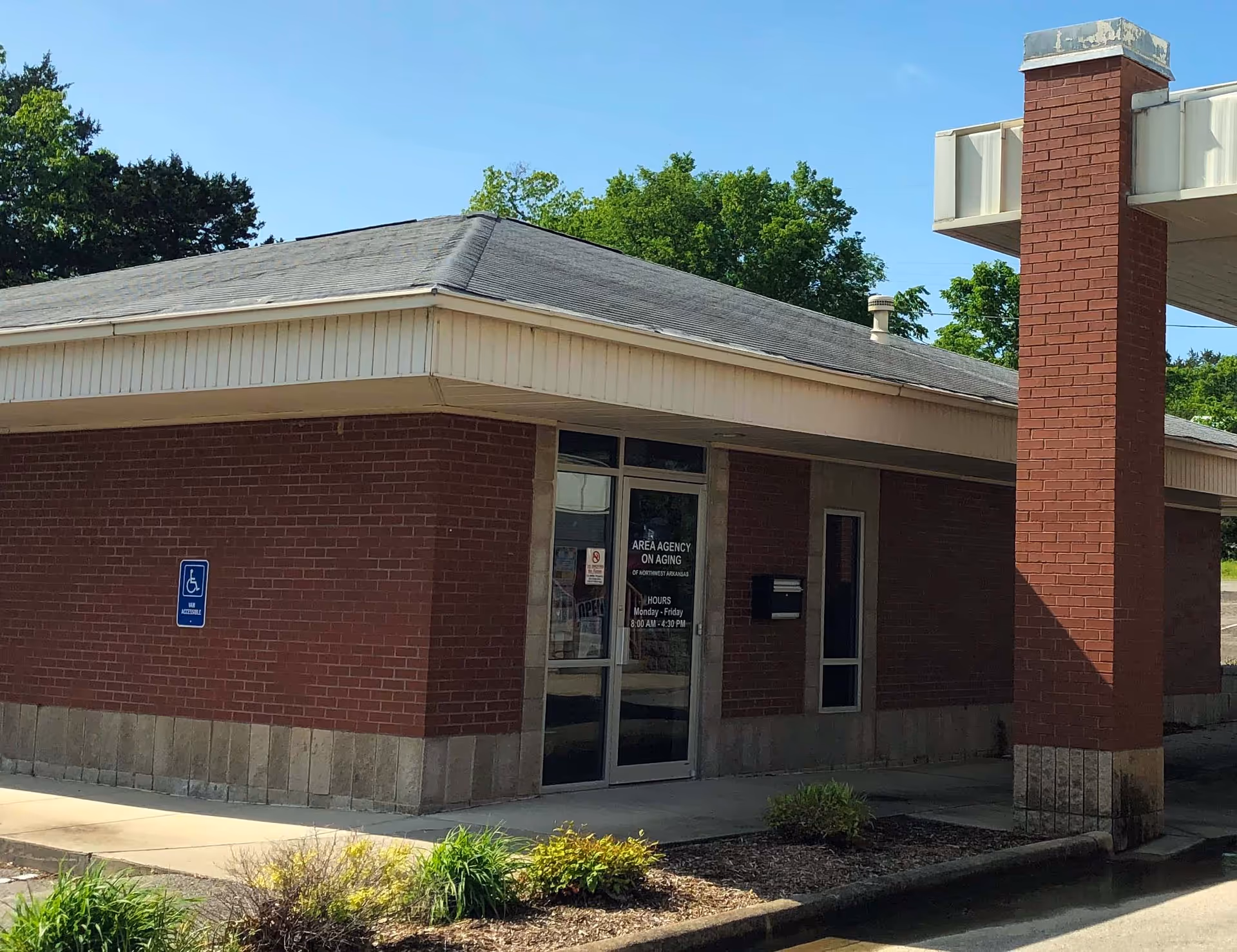 Brick facility exterior with glass entrance and signage for Area Agency on Aging.