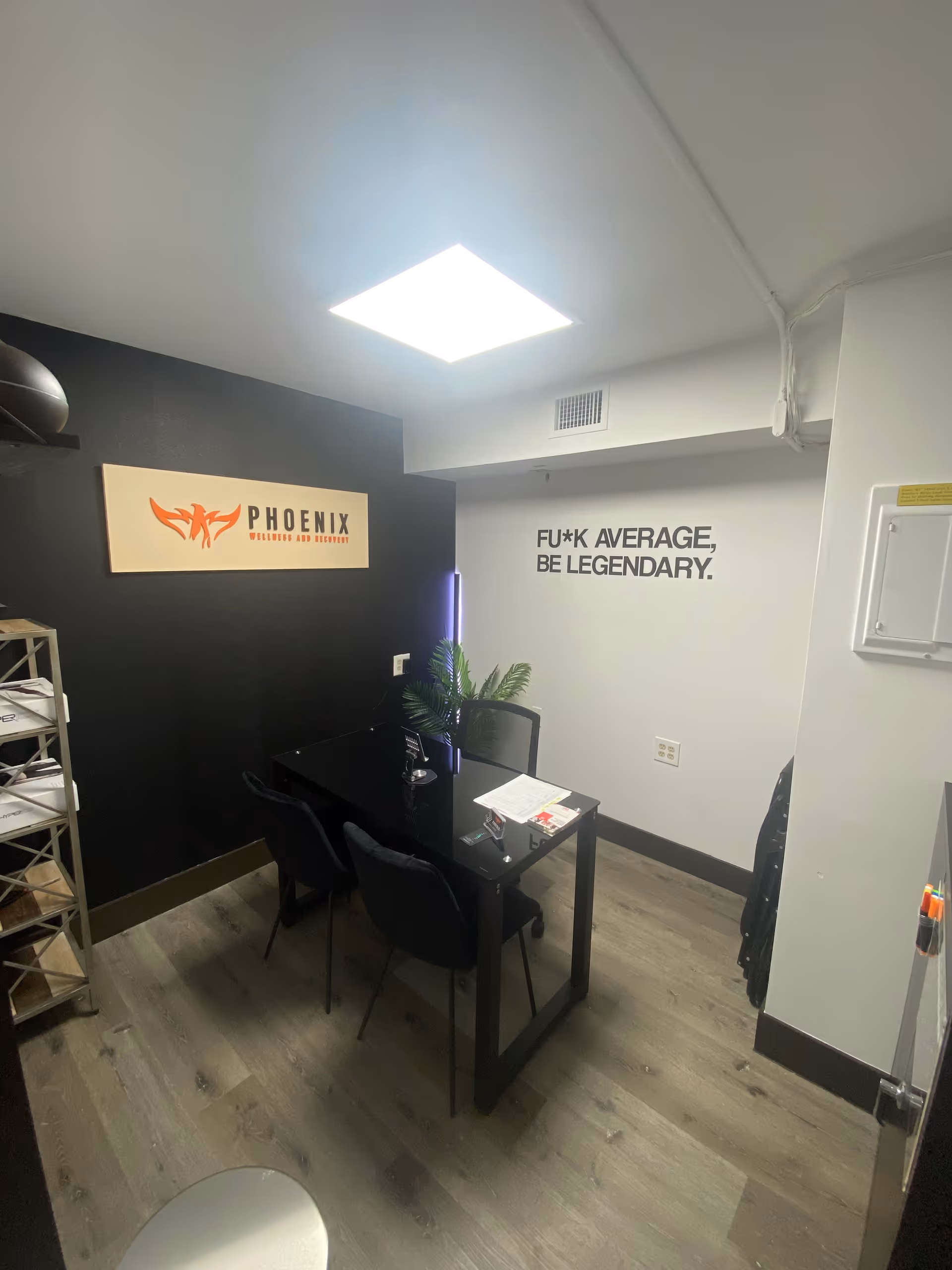 Small office meeting room at Phoenix Wellness & Recovery with sign, desk, and chairs.