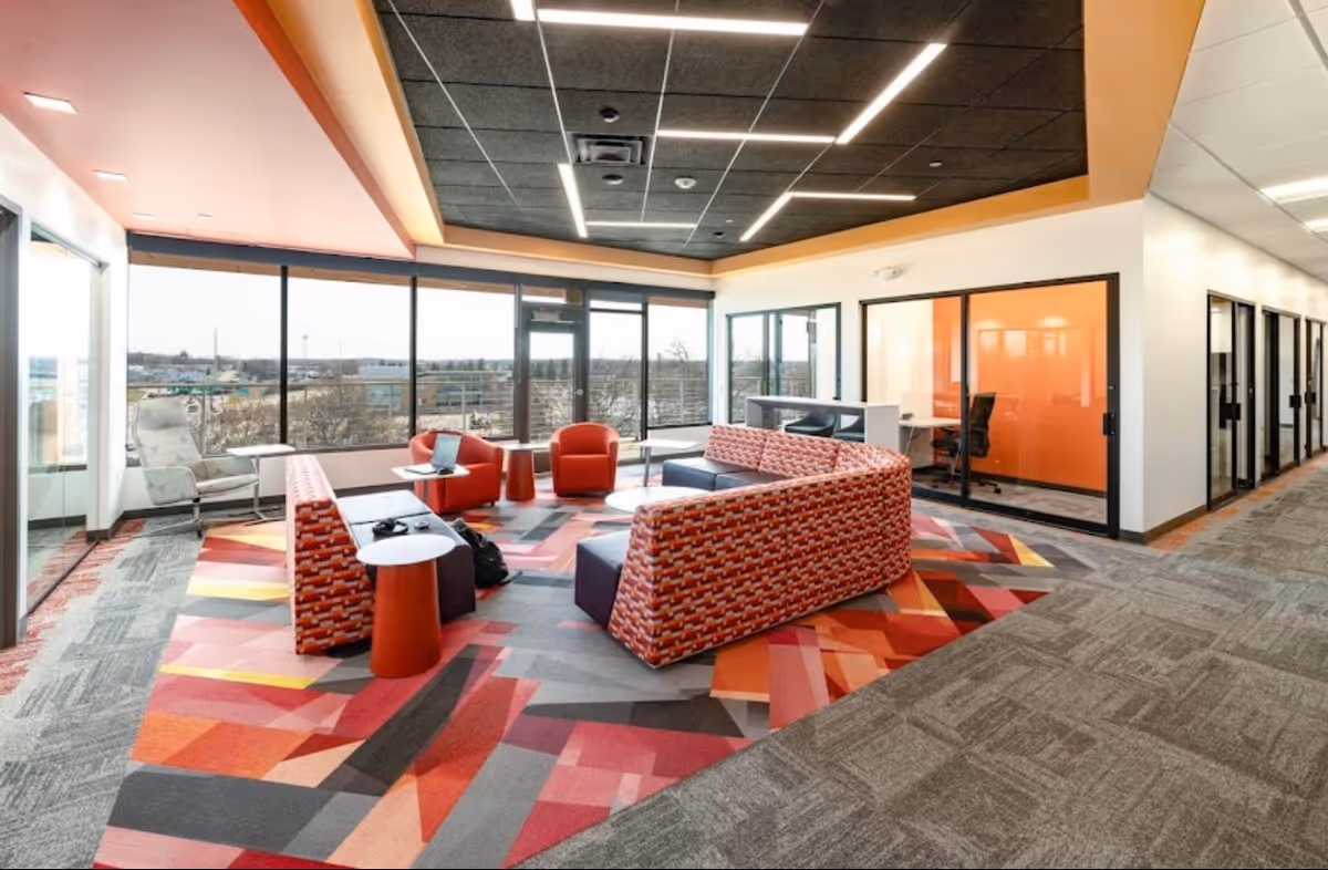 Bright modern lounge area in a senior living facility with red seating.
