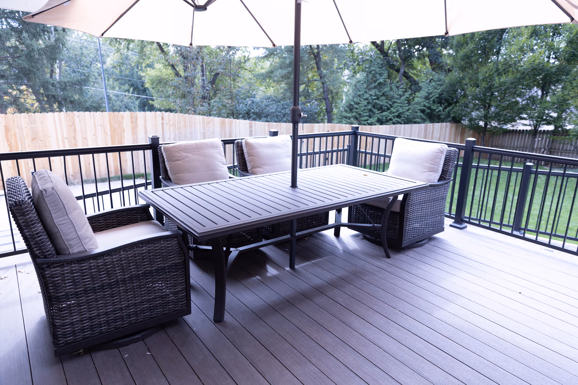 Outdoor patio with wicker dining set and umbrellas on a wooden deck