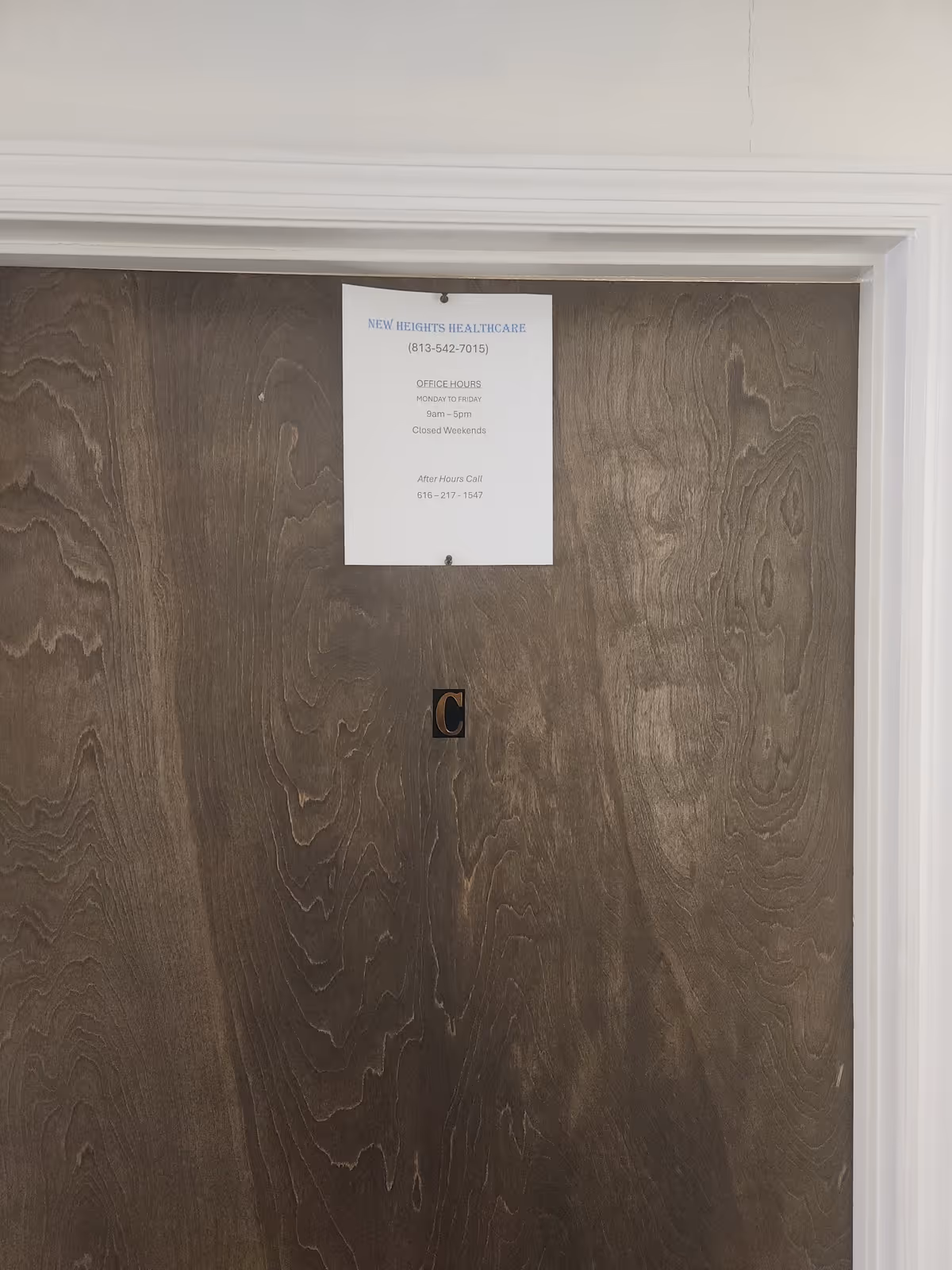 Interior wooden door with a posted notice from New Heights Healthcare.