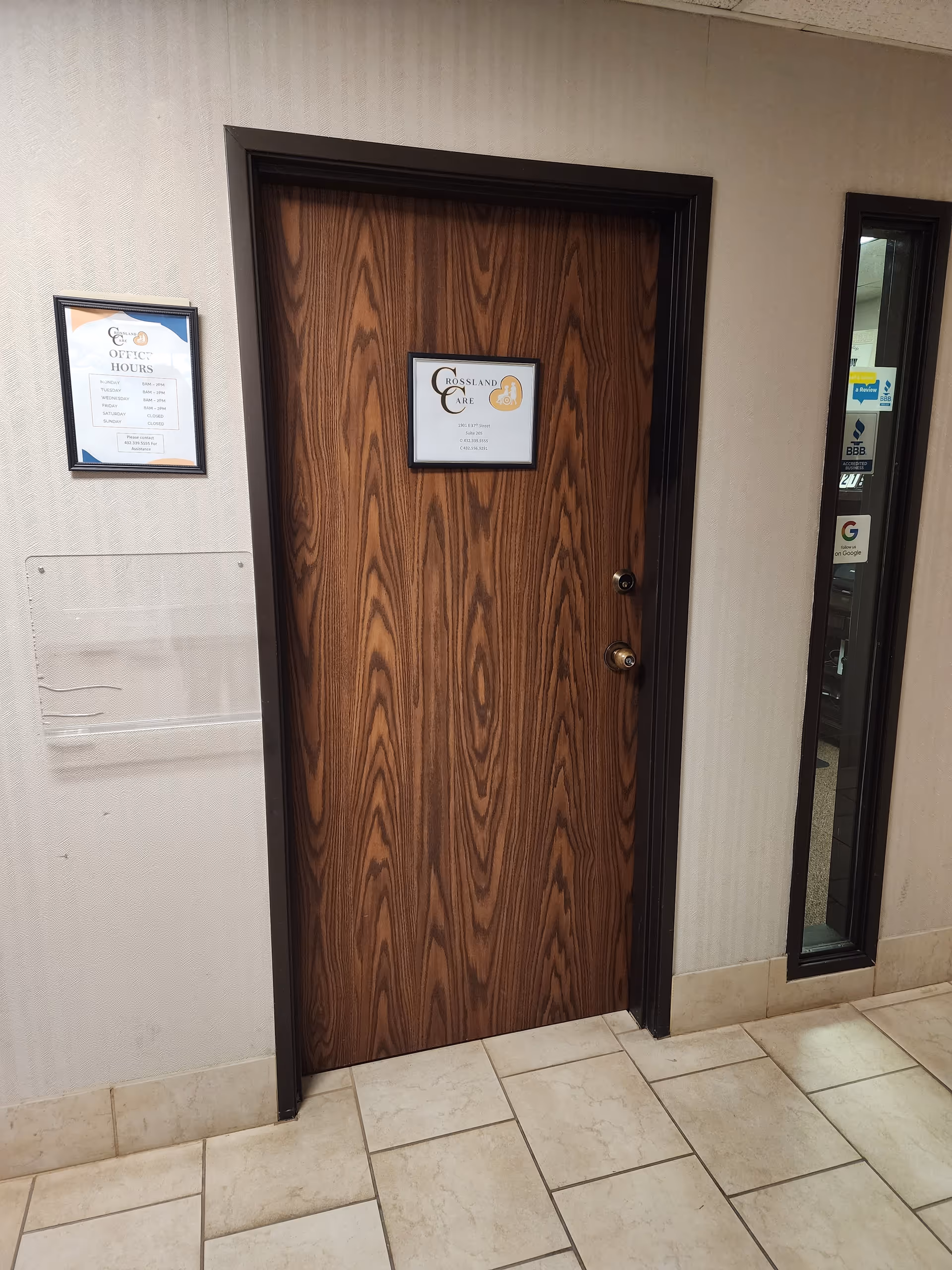 Wooden doorway labeled Crossland Care, with window and notices in a tiled hallway.