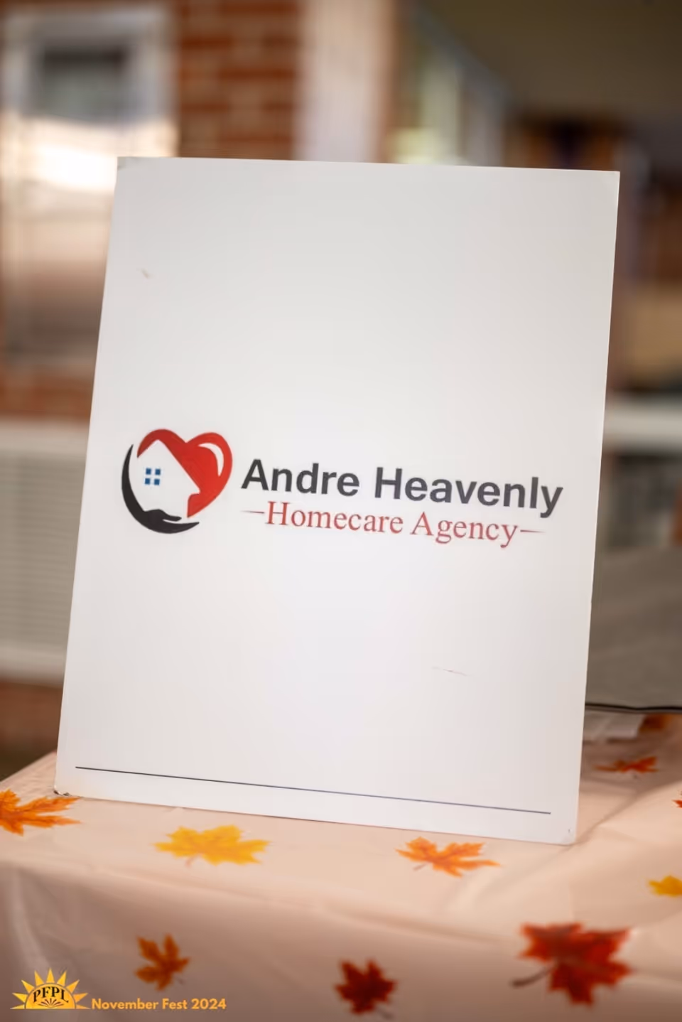 White sign bearing Andre Heavenly Homecare Agency logo on an autumn-leaf tablecloth