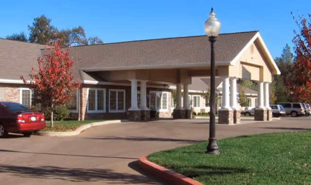 Exterior view of Martin House senior living facility front entrance with driveway and cars.