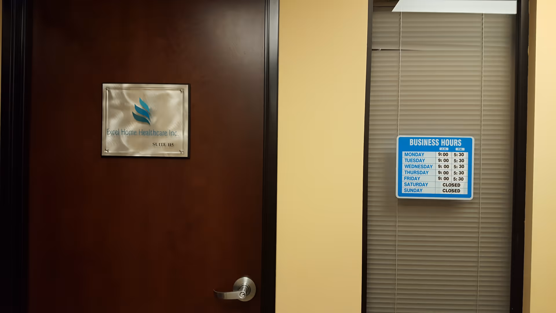 Wooden door with Excel Home Healthcare Inc. plaque and a window with blinds beside it.