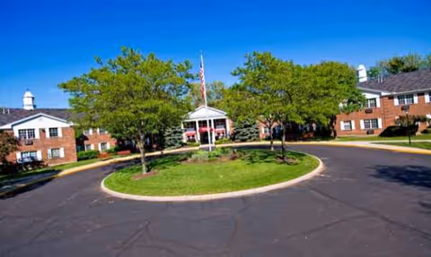 Exterior view of Oakleaf Village of Toledo with circular driveway, lawn, and entrance.