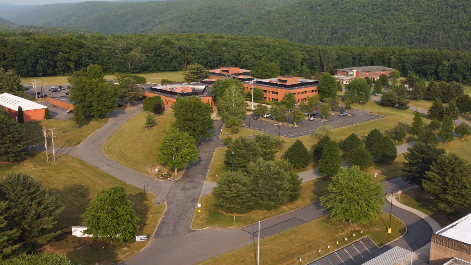 Aerial view of Weatherwood Healthcare and Rehabilitation Center campus with brick buildings and surrounding trees.
