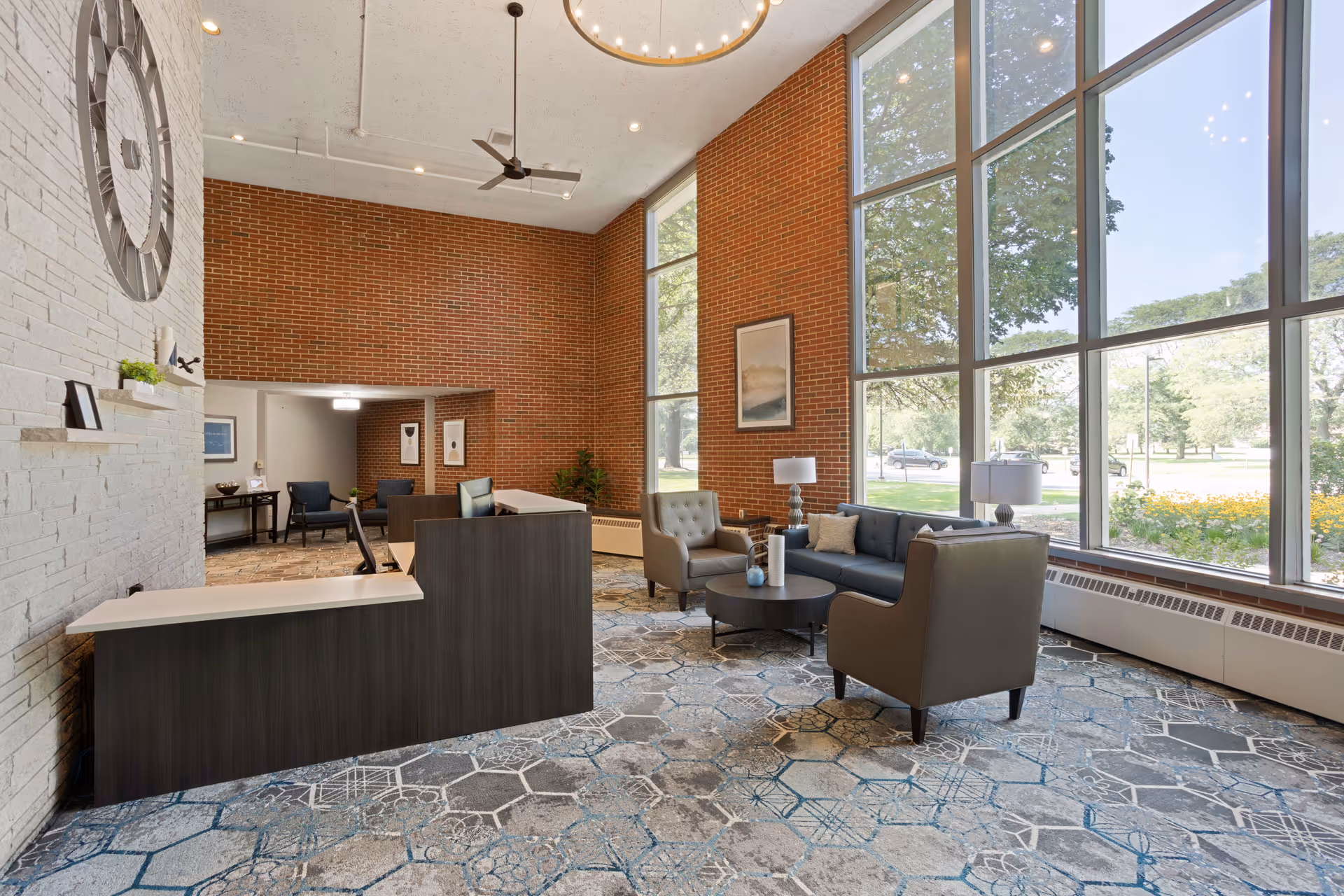 Bright senior living lobby with large windows, brick walls, and modern seating.