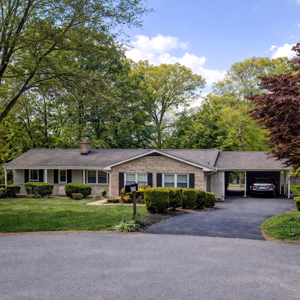 Ashleigh's Place exterior: a single-story brick building with a carport, driveway, and trees.