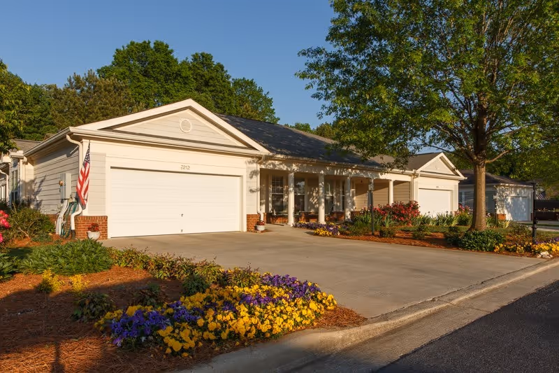 One-story residential unit with attached two-car garage, front porch and landscaped flowerbeds.