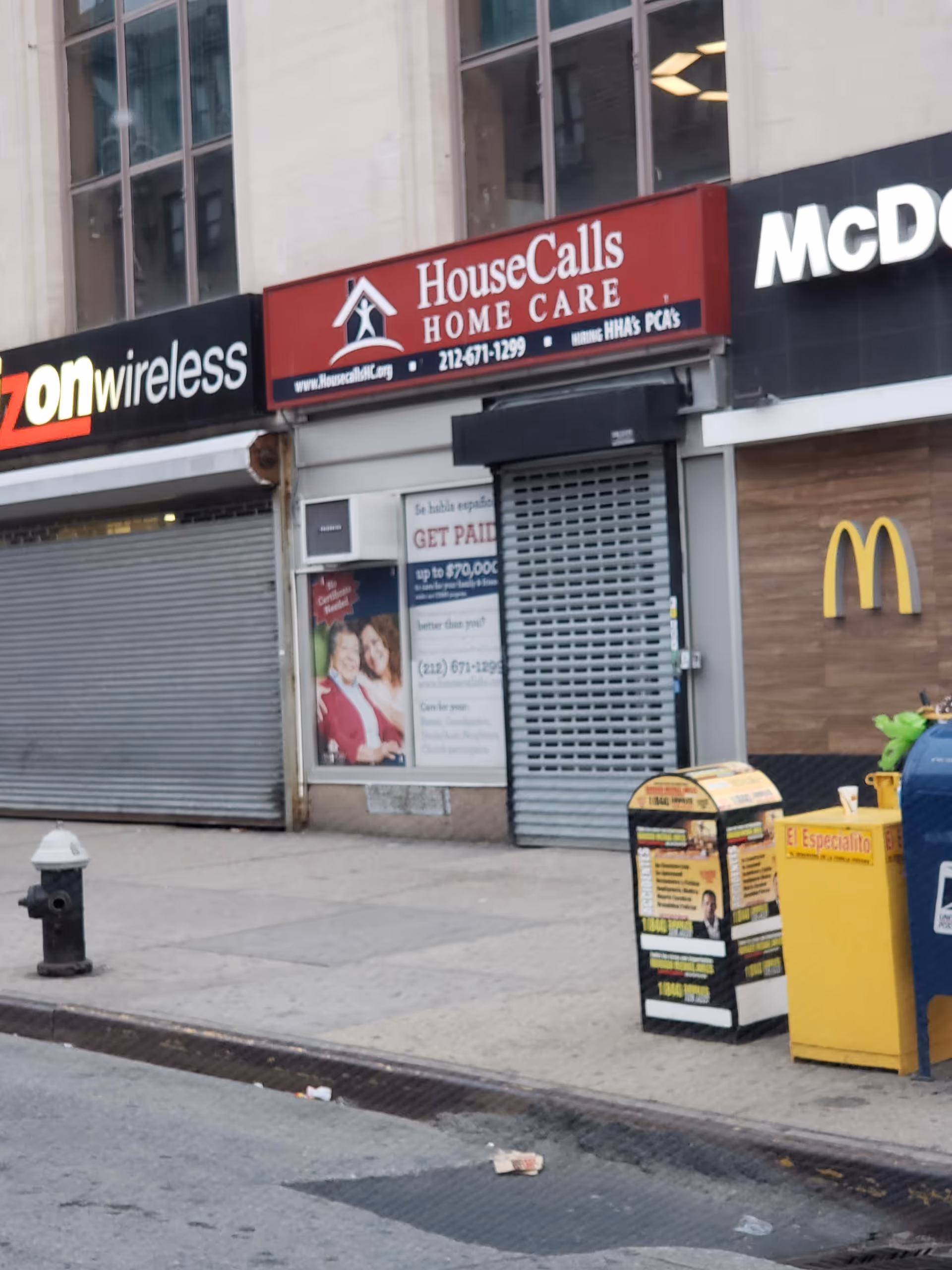 City storefronts on a sidewalk featuring a House Calls Home Care sign.