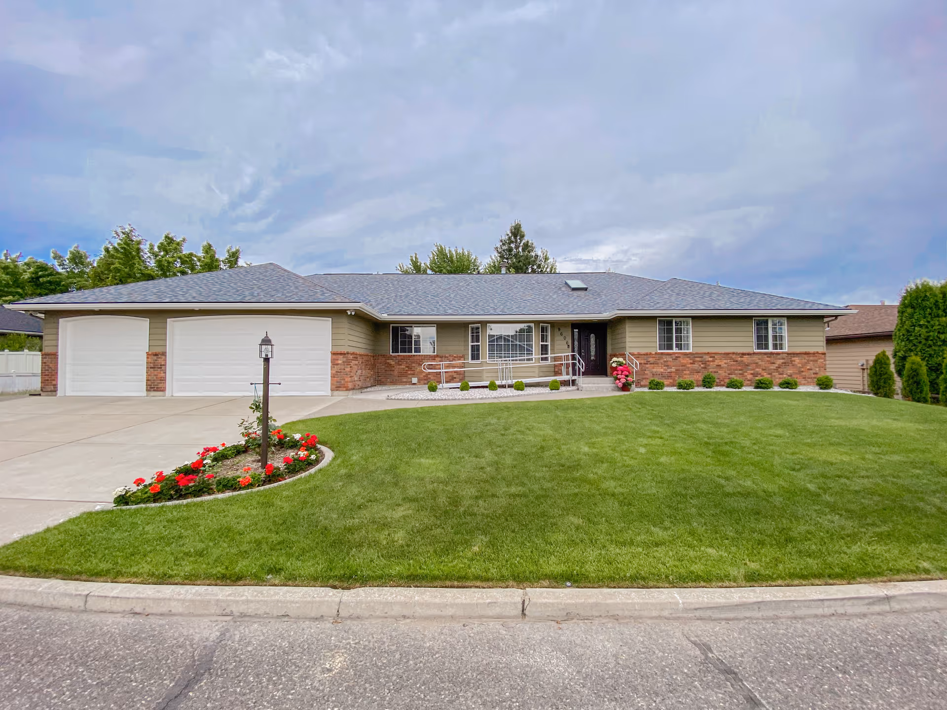 Front view of a single-story facility with a three-car garage and manicured lawn.