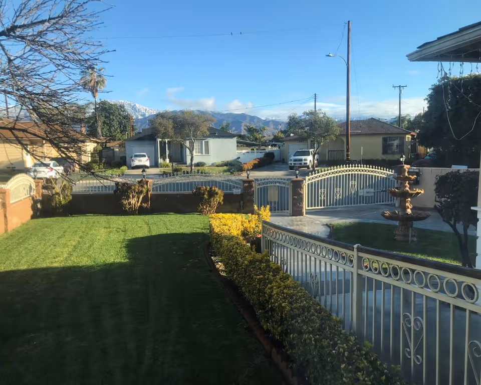 Front yard and gate of Baldwin Gracious Living with fountain and manicured lawn