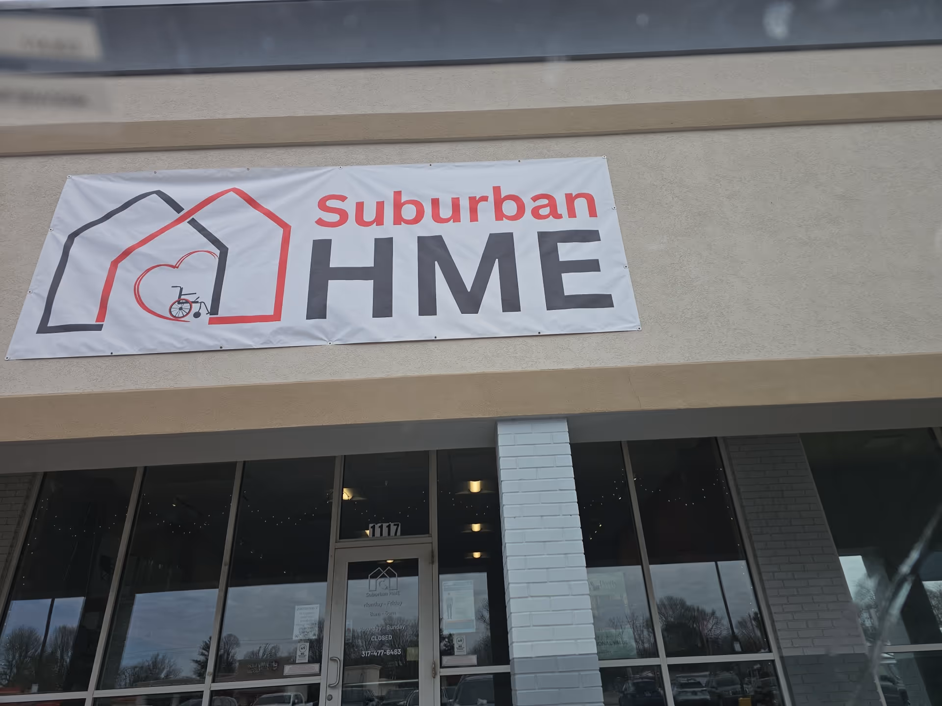 Exterior of a building with a Suburban HME banner for Hancock Home Medical Equipment.