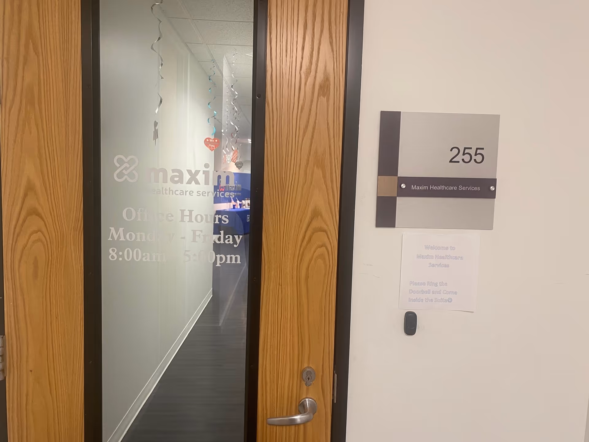 Office doorway with Maxim Healthcare Services sign and hallway beyond.