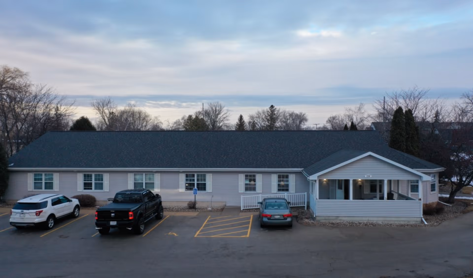 Exterior view of Care Partners Assisted Living, a single-story building with a covered entrance and cars.