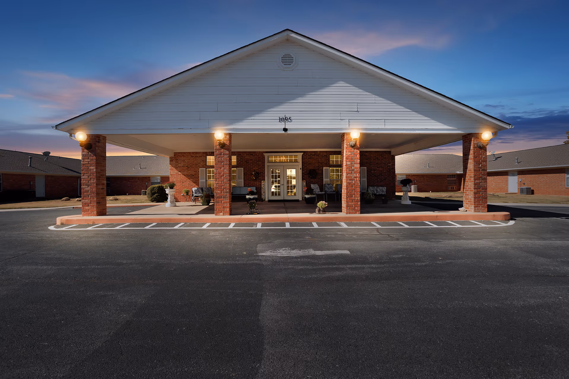 Front view of Canoe Brook Assisted Living entrance with brick columns and a porte-cochère.