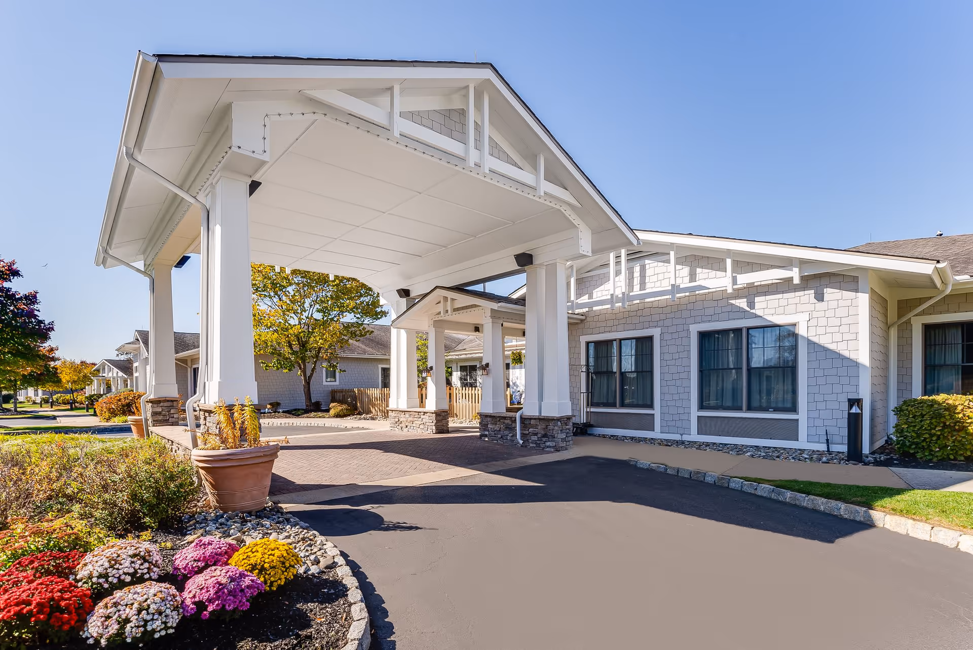 Entrance to a Sunrise of Jackson senior living facility with a covered driveway and landscaping.