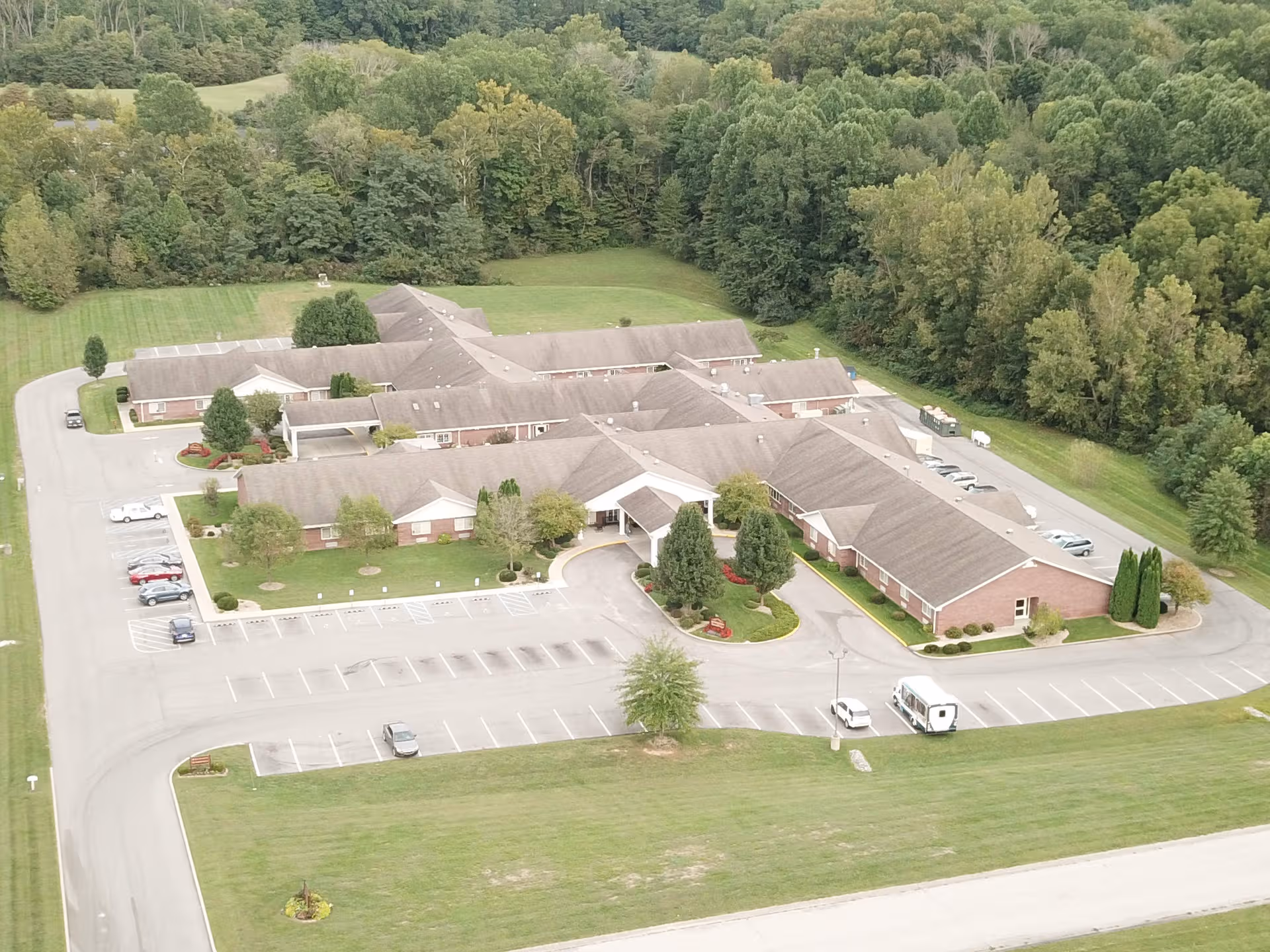 Aerial view of StoneBridge Health Campus with brick buildings, parking lot, and trees.