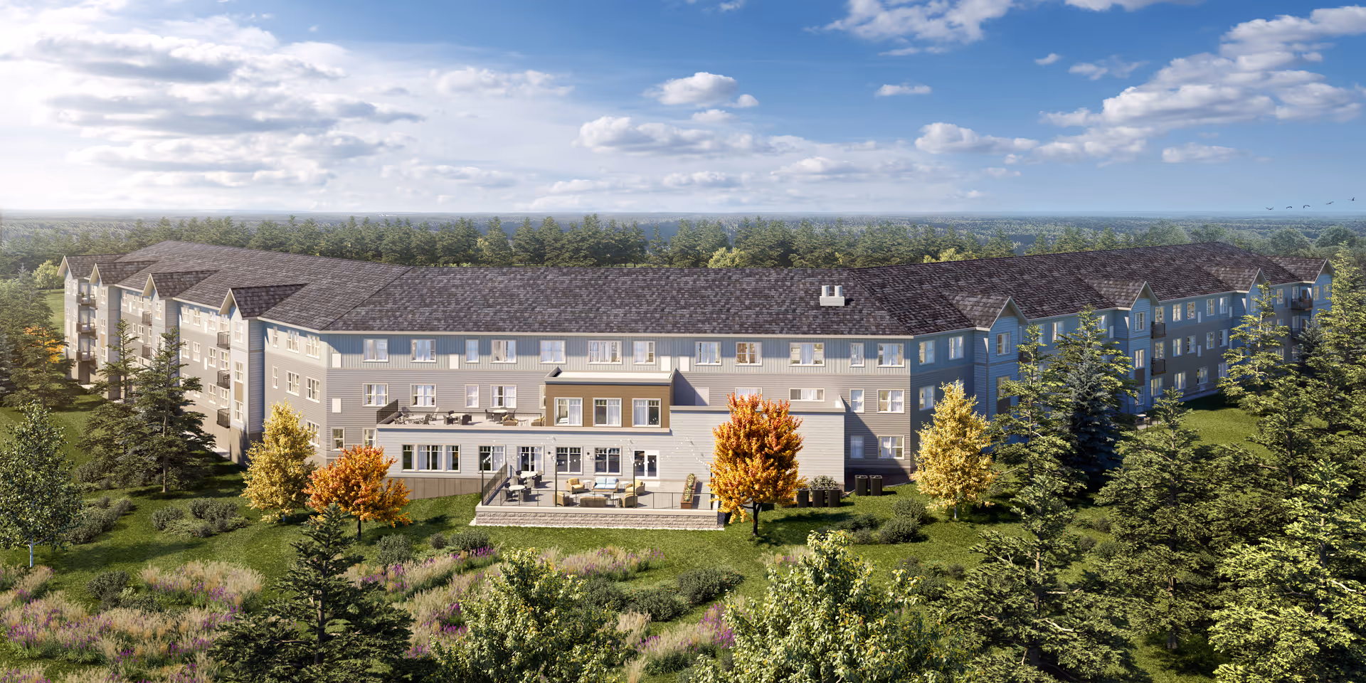 A large multi-wing senior living facility with manicured grounds and surrounding trees.