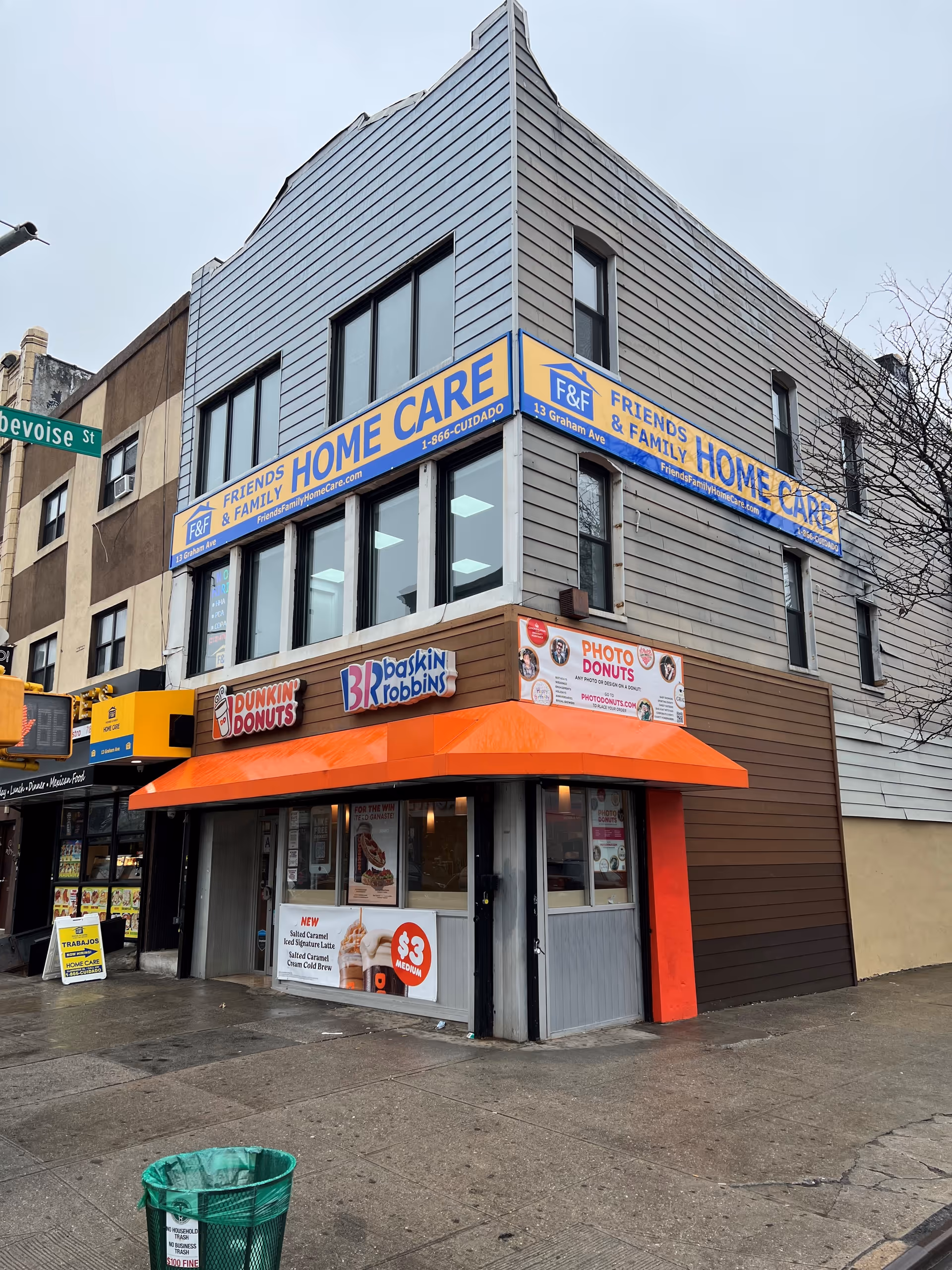 Corner building facade with a Friends and Family Home Care sign above a Dunkin Donuts entrance.
