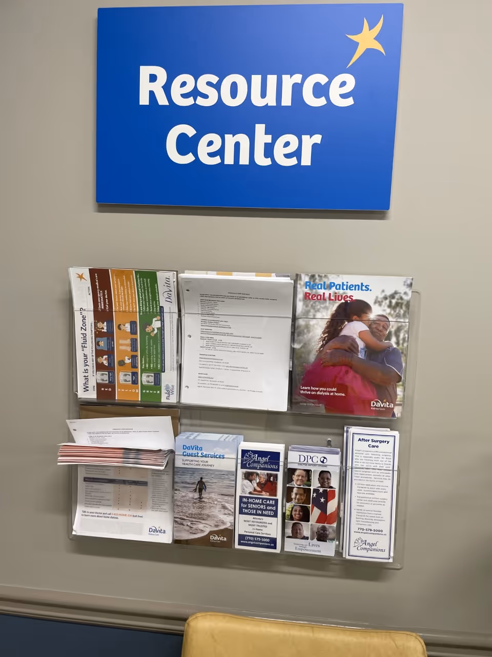 Blue Resource Center sign above a wall-mounted brochure rack with pamphlets.