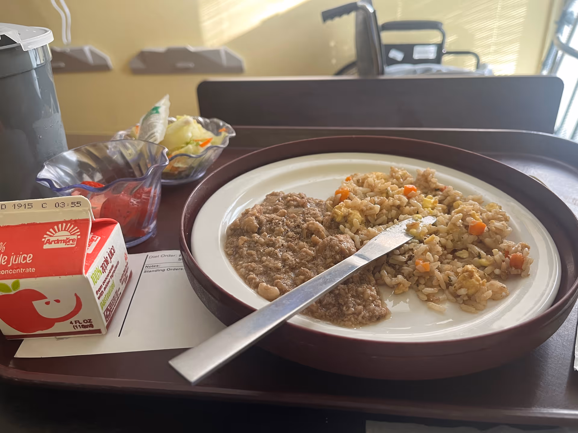 Meal tray with beef and fried rice on a brown plate.