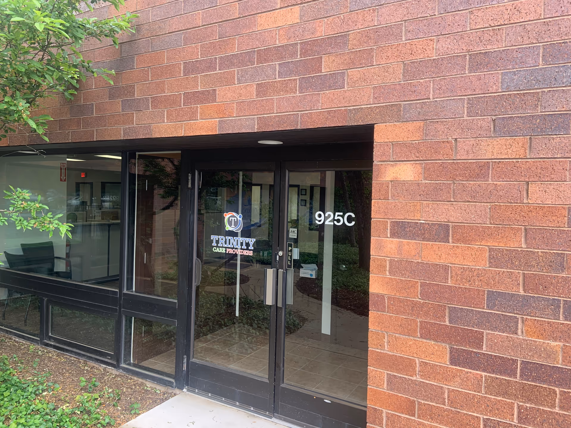 Brick exterior entrance with glass doors labeled Trinity Care Providers, address 925C.