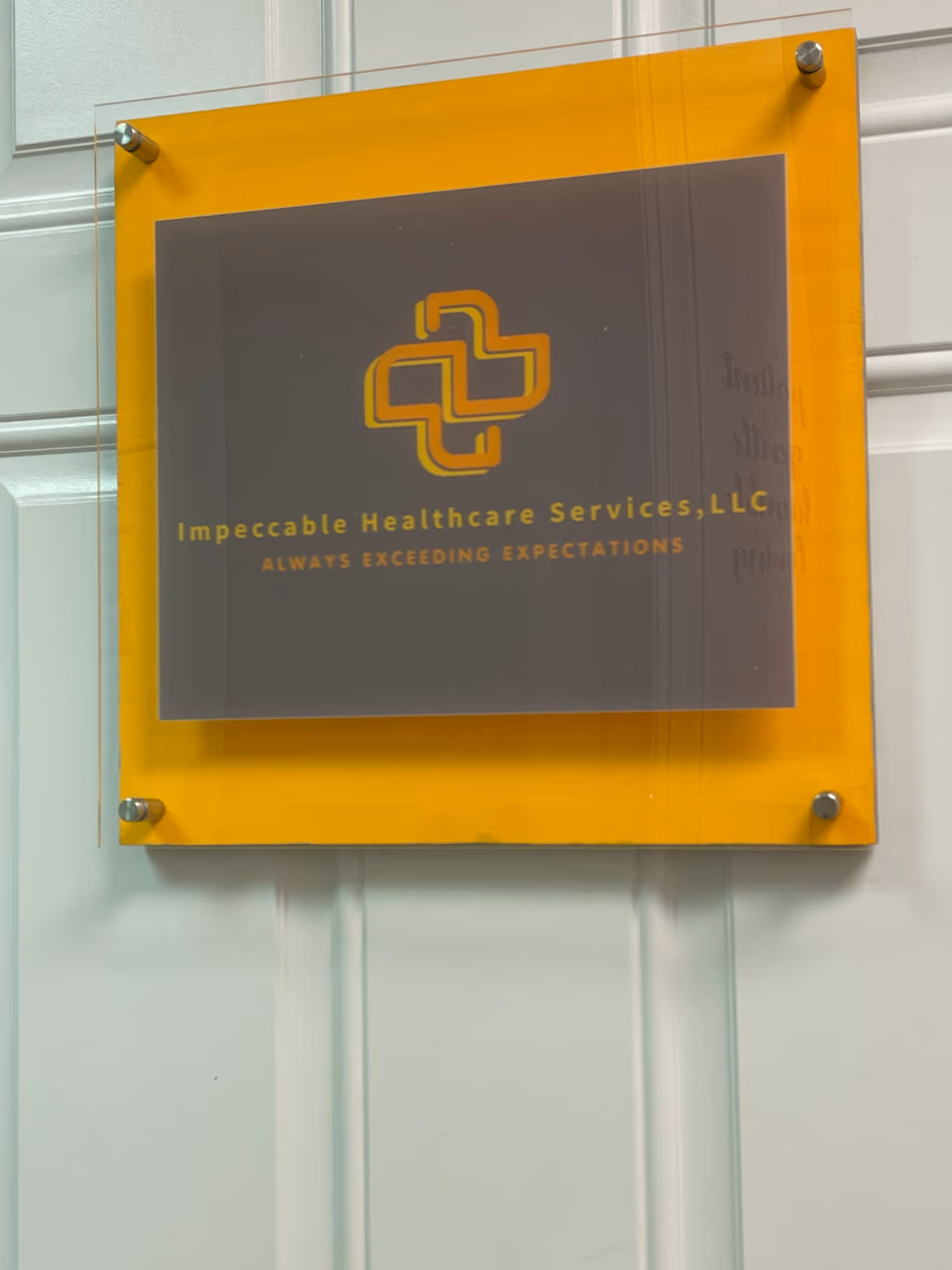 Yellow-framed wall plaque displaying Impeccable Healthcare Services, LLC logo and motto.
