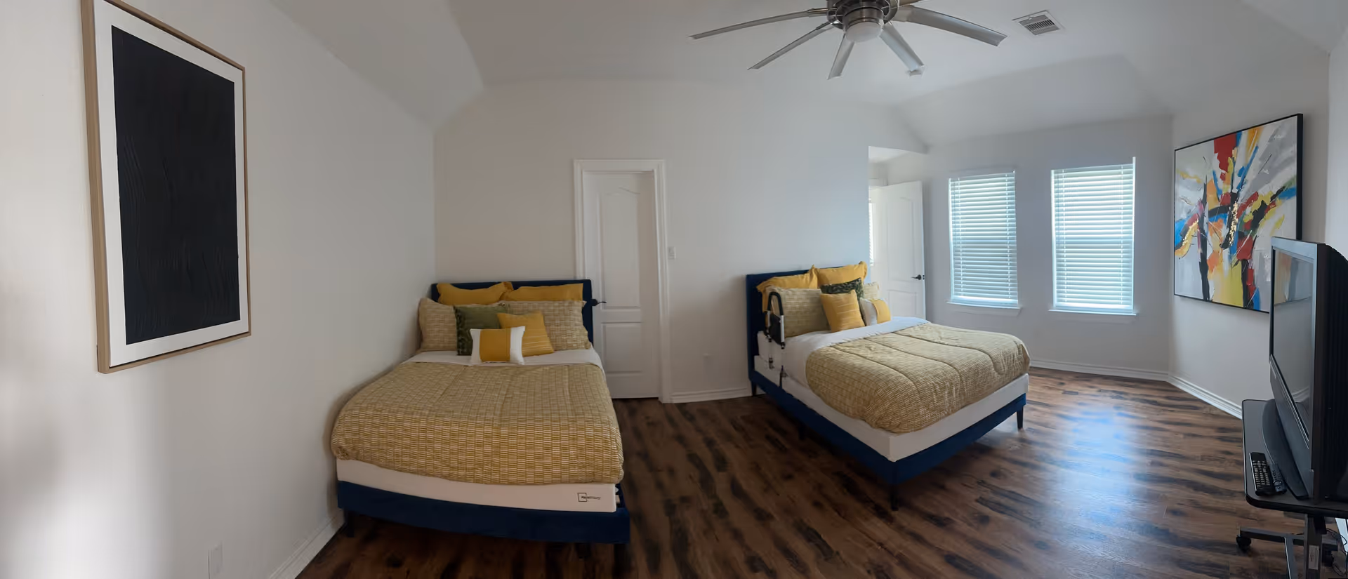 Bright shared bedroom with two twin beds, wood floors, and modern decor.