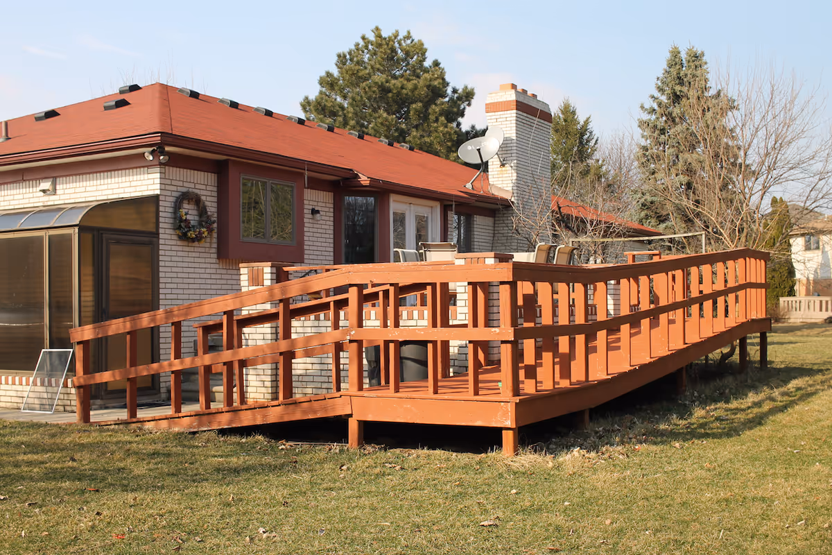 Exterior view of a single-story facility with an orange wooden ramp and patio seating.