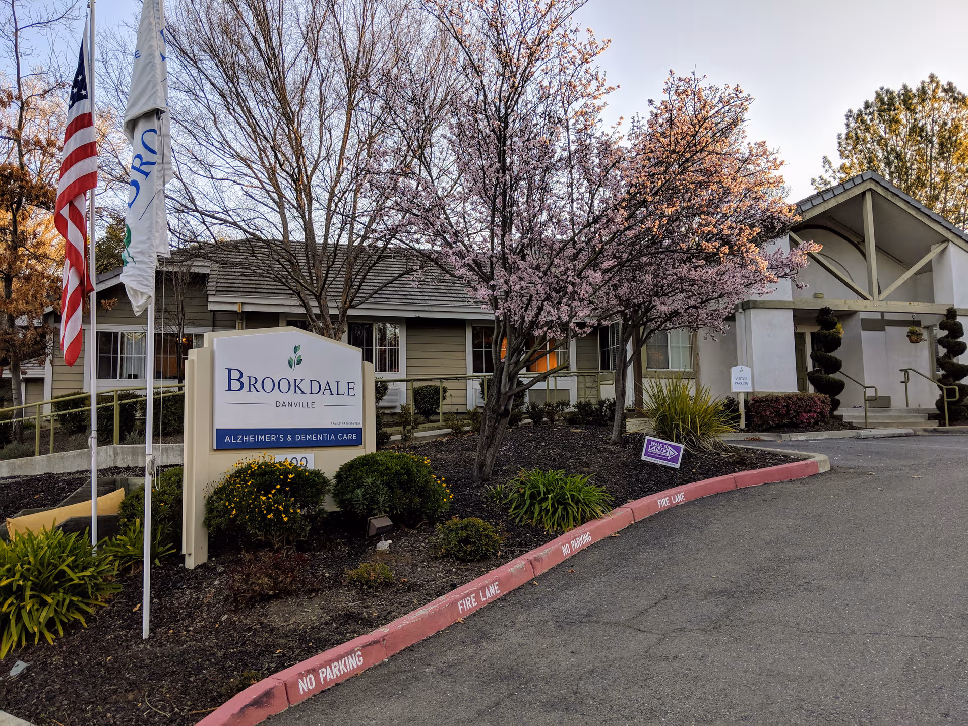 Brookdale Danville Alzheimer's and Dementia Care facility exterior with sign, trees, and flags.