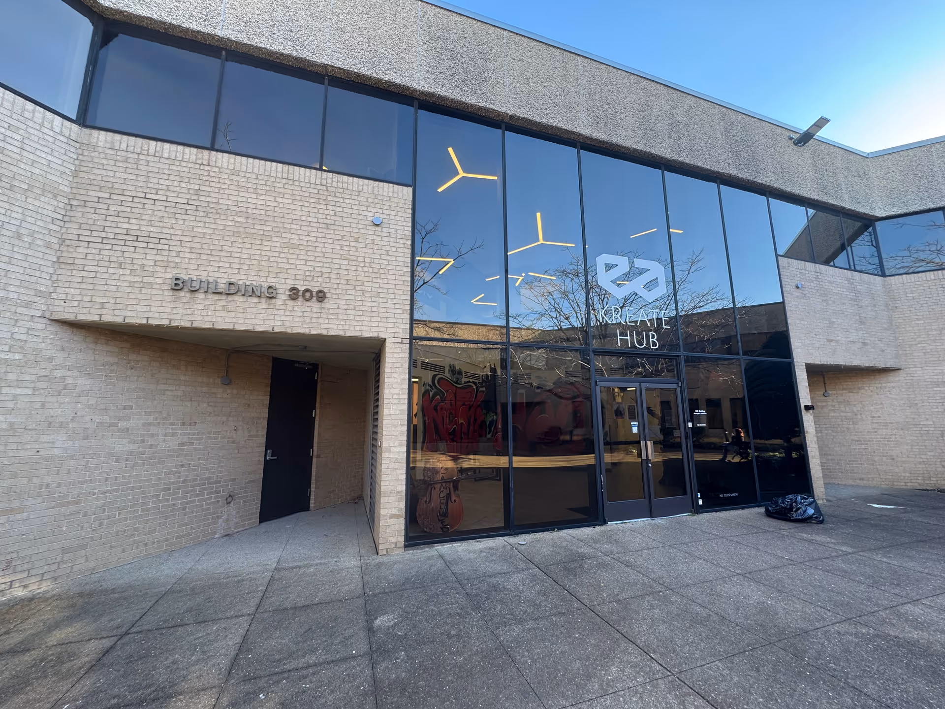 Exterior view of brick building entrance with large glass doors labeled Creative Hub.