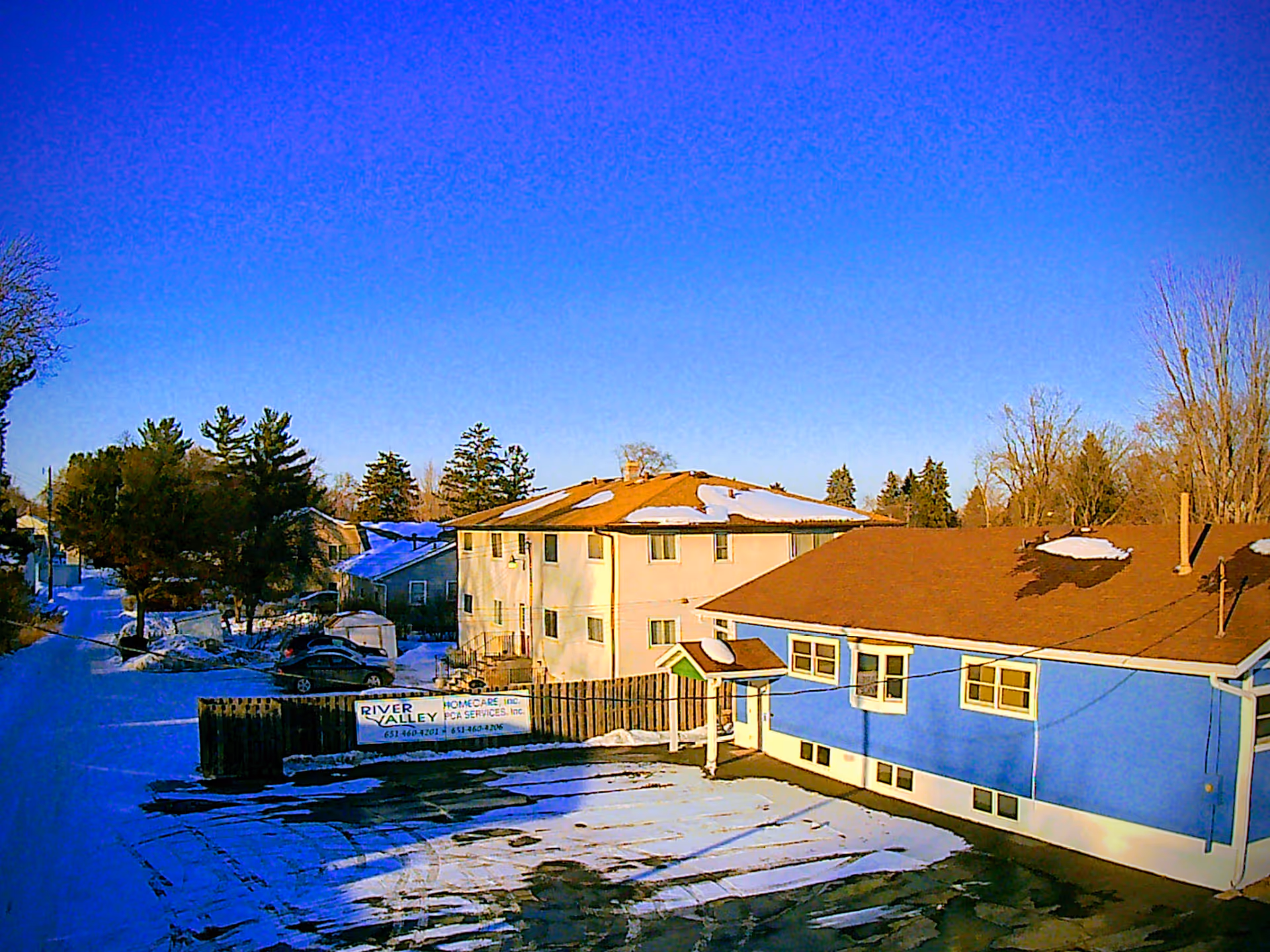 Snowy outdoor view of River Valley building with a blue exterior under a clear sky.