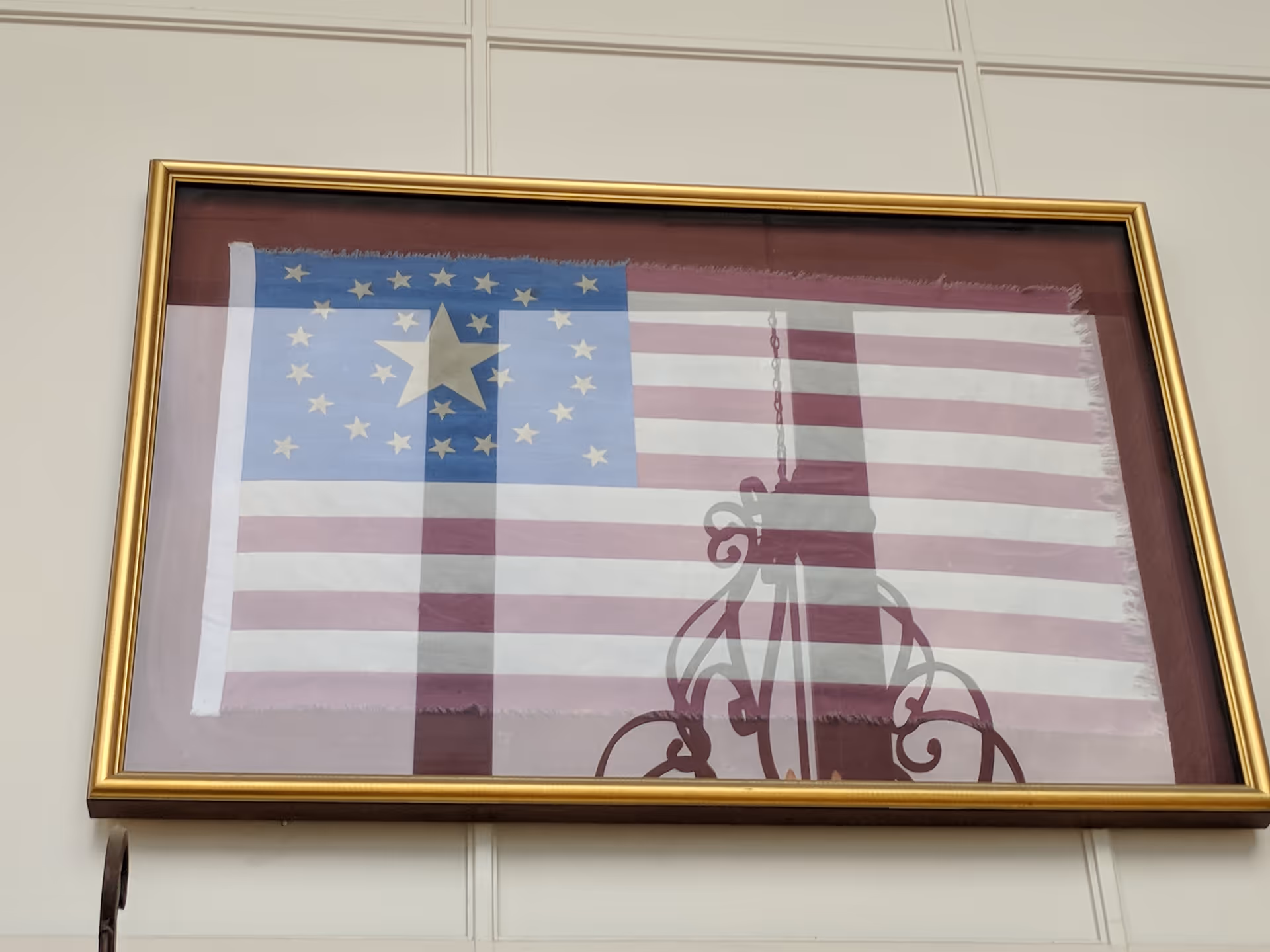 Framed American flag artwork hanging on a wall in a building interior.