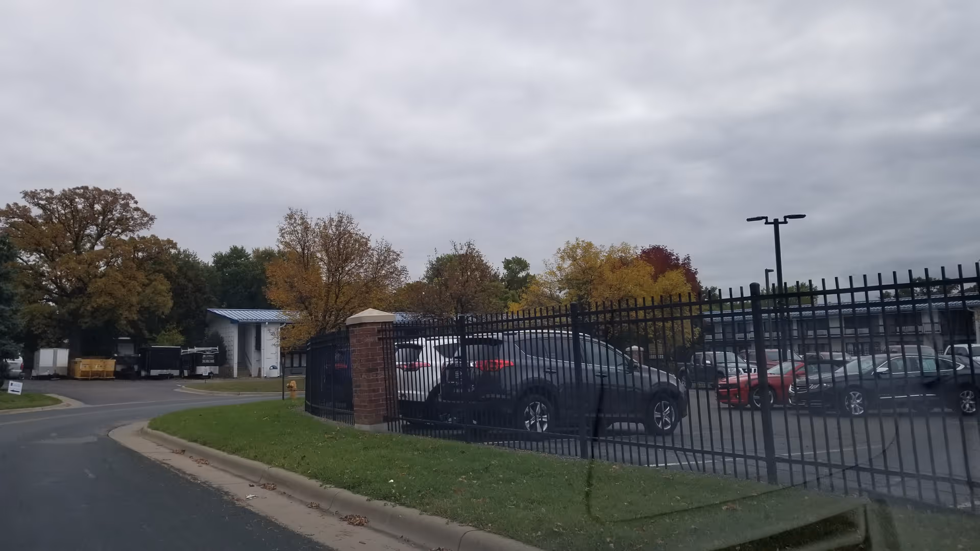 Gated parking lot at a senior living facility with autumn trees.