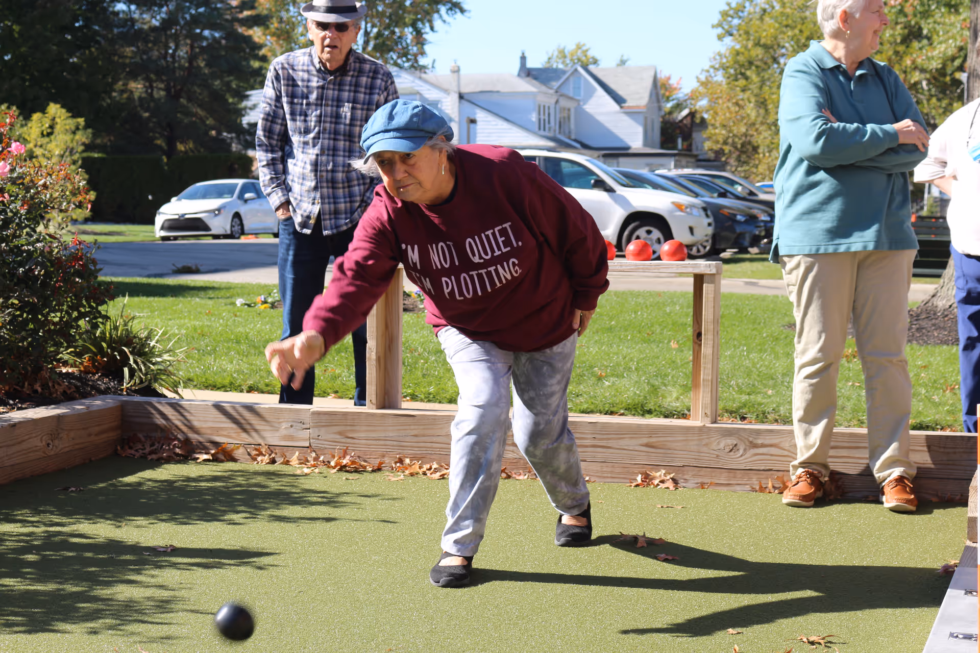 Senior residents play bocce on an outdoor court at the facility.
