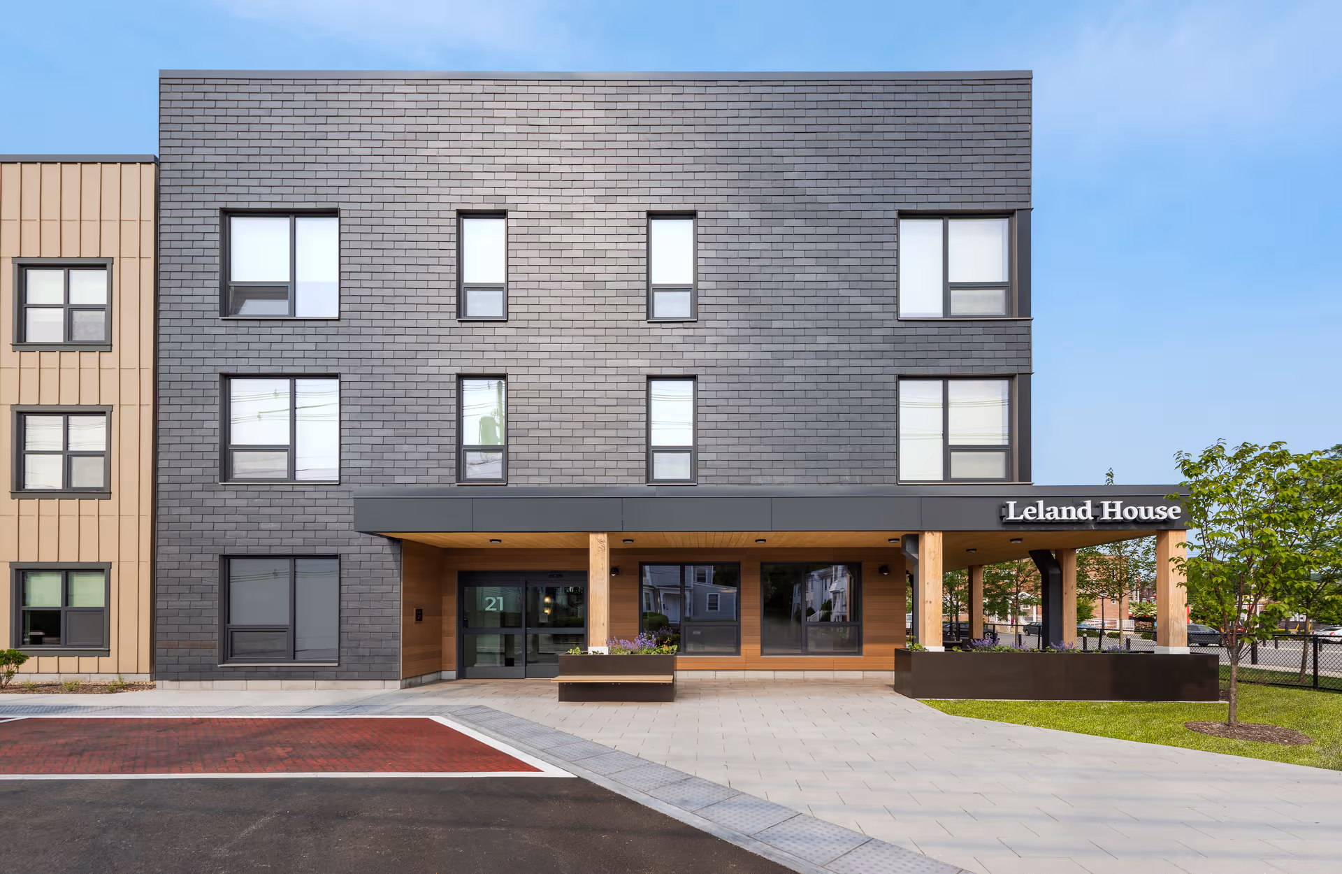 Modern three-story building with Leland House entrance under a covered walkway.