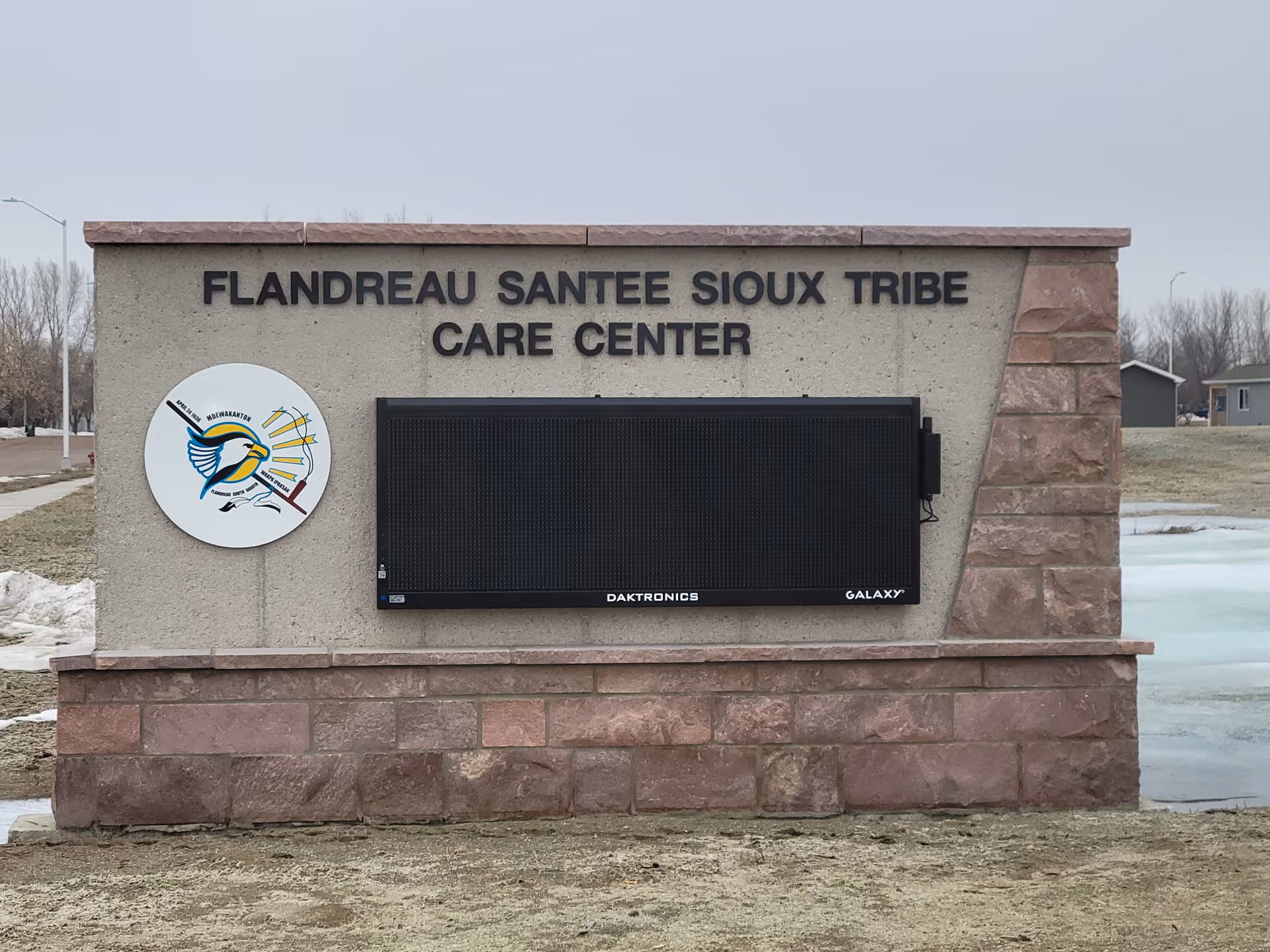 Exterior stone sign reads Flandreau Santee Sioux Tribe Care Center with a large digital display
