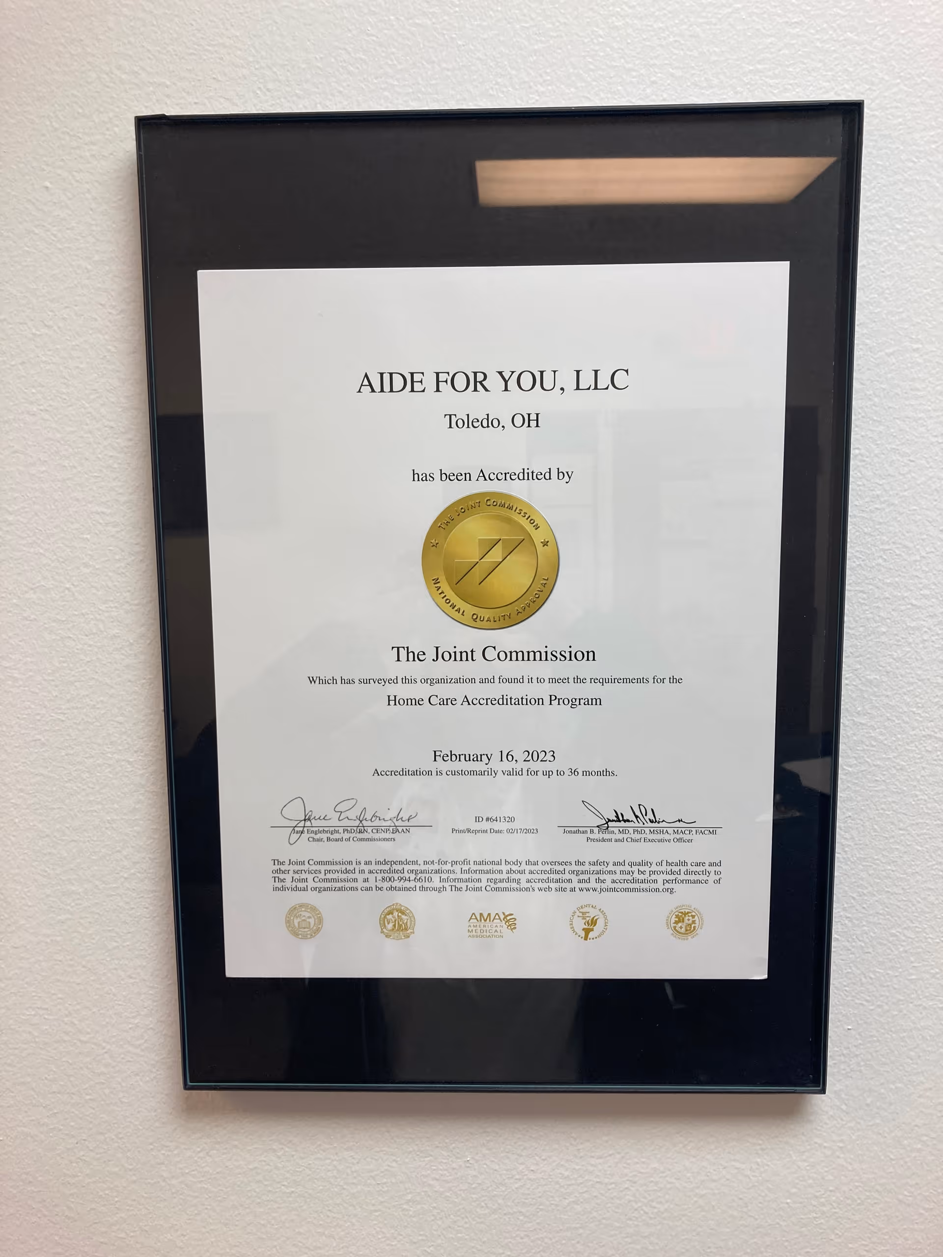 Framed accreditation certificate on a light interior wall.