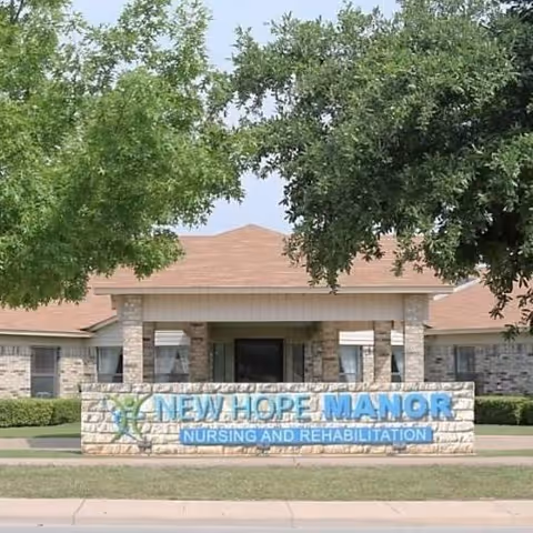 Front view of New Hope Manor nursing and rehabilitation facility sign with trees.