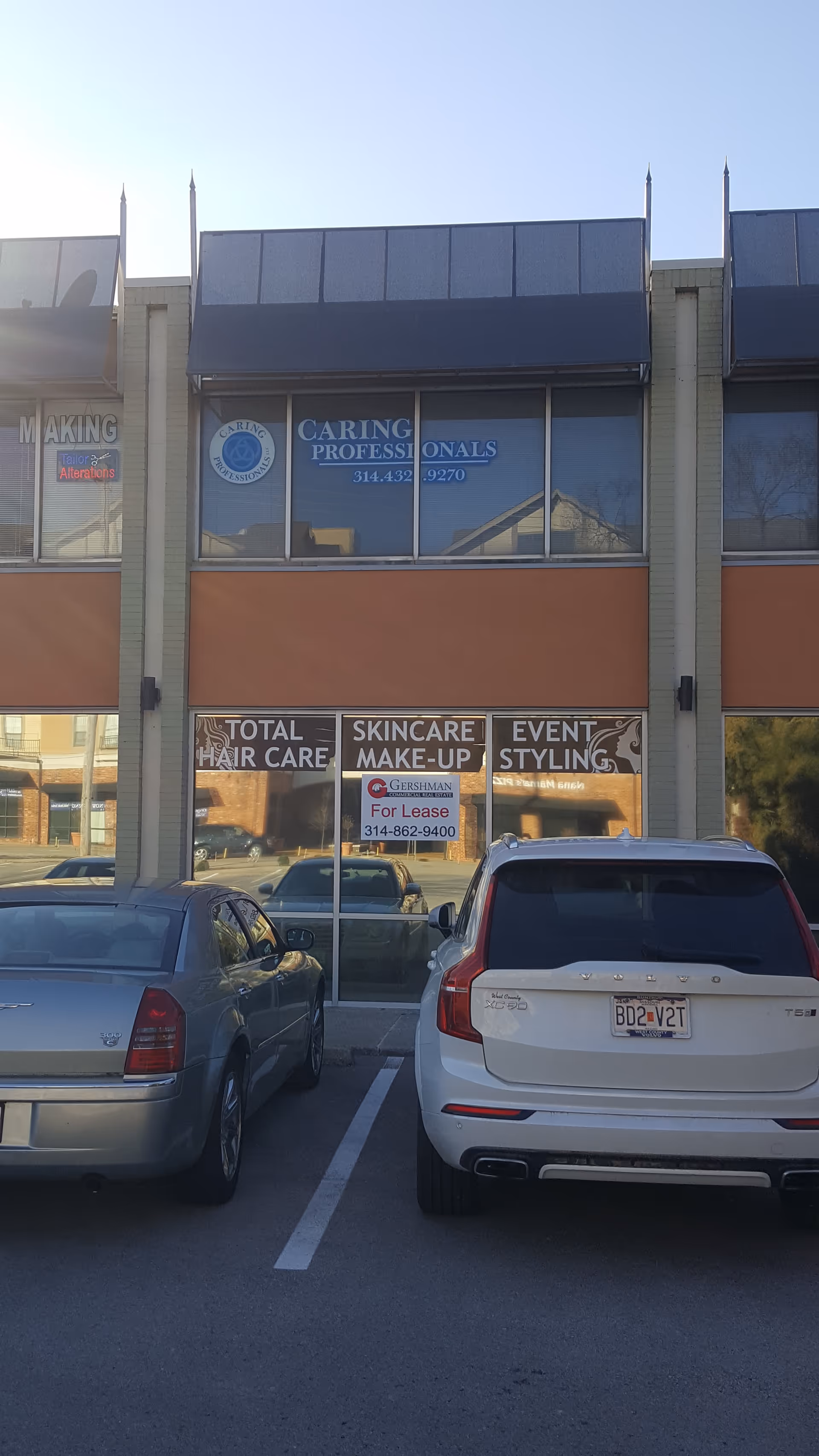 Exterior of a strip mall featuring Caring Professionals sign and parked cars.